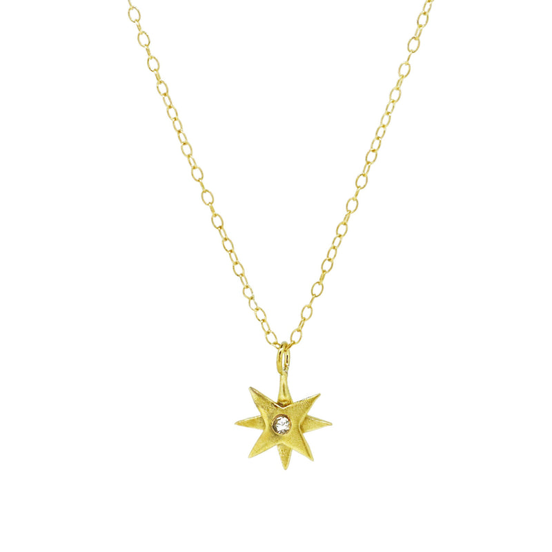 gold star necklace set with a white sapphire 